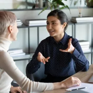 Multiracial colleagues talking while working on common project in office