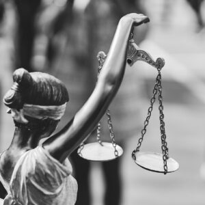 Rear view of themis statue with balance scales in black and whit